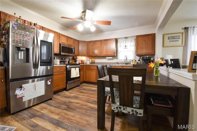 311 S Hibbard St, Staunton, IL 62088 - kitchen featuring appliances with stainless steel finishes, a textured ceiling, dark wood-style flooring, a ceiling fan, and brown cabinetry