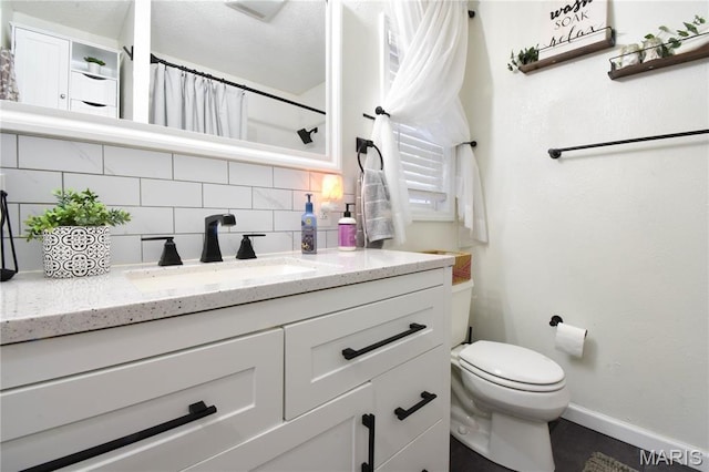 311 S Hibbard St, Staunton, IL 62088 - bathroom with tasteful backsplash, baseboards, vanity, toilet, and a shower with curtain