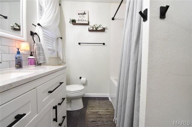 311 S Hibbard St, Staunton, IL 62088 - full bathroom with decorative backsplash, vanity, toilet, shower / bath combo with shower curtain, and baseboards