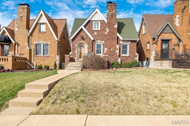 5453 Tholozan Ave, Saint Louis, MO 63109 - tudor home featuring brick siding, a chimney, and a front lawn