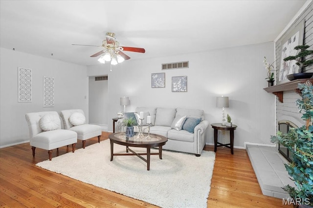 1115 Pinrun Dr, Ballwin, MO 63011 - living room featuring ceiling fan, wood finished floors, baseboards, and a brick fireplace