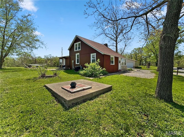 view of grassy yard with cooling unit and a detached garage