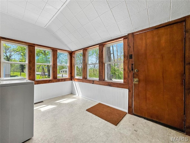 unfurnished sunroom with washer / dryer and vaulted ceiling