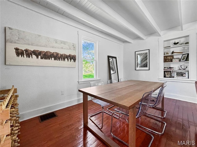 dining room with beam ceiling, dark wood finished floors, built in features, and baseboards
