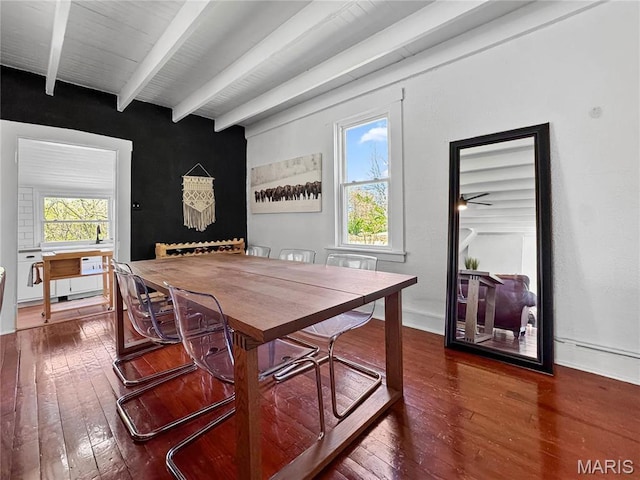 dining room with dark wood-type flooring and beam ceiling