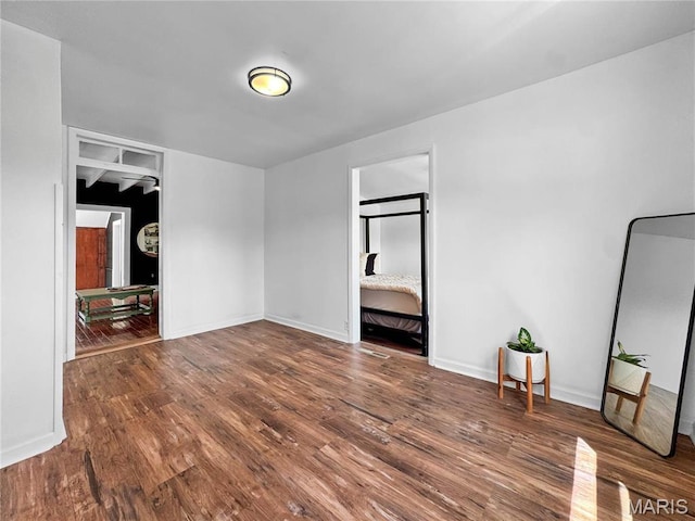 unfurnished bedroom with wood finished floors and baseboards