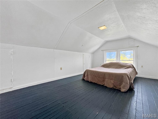 bedroom featuring lofted ceiling, baseboards, dark wood-style flooring, and a textured ceiling