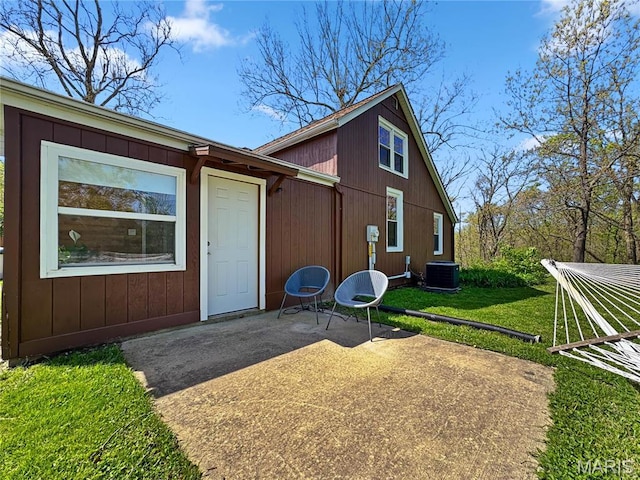 rear view of property with a patio area, cooling unit, and a lawn