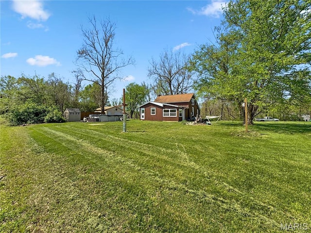 view of green lawn with an outbuilding and a storage shed