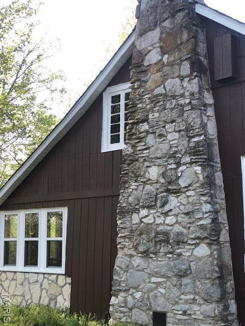 view of home's exterior featuring stone siding and a chimney