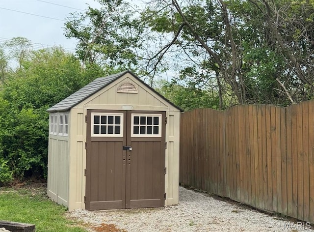 view of shed featuring fence