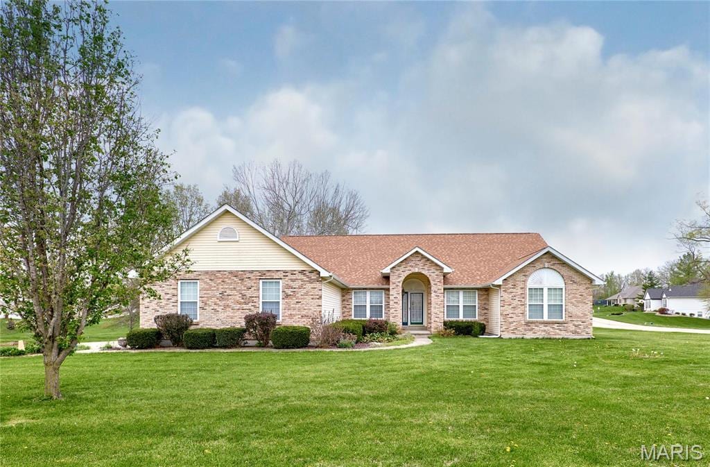 ranch-style home featuring a front lawn, brick siding, and a shingled roof