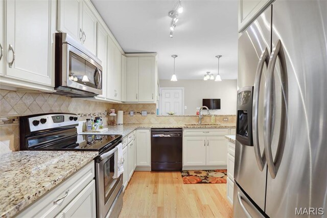 1709 Highview Circle Ct, Ballwin, MO 63021 - kitchen with stainless steel appliances, a sink, light wood finished floors, decorative backsplash, and decorative light fixtures