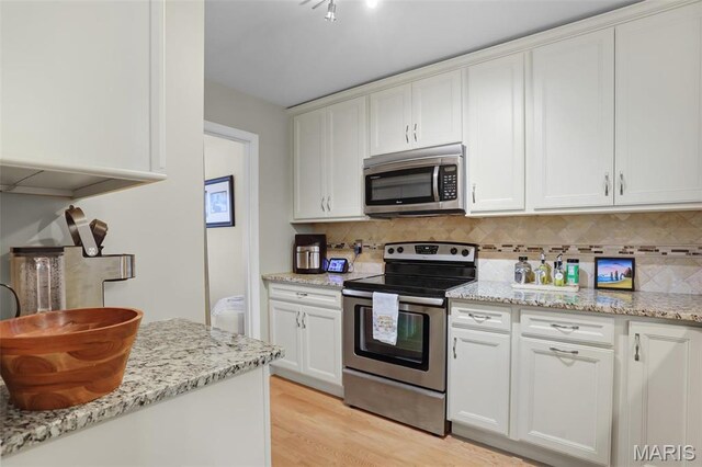 1709 Highview Circle Ct, Ballwin, MO 63021 - kitchen with appliances with stainless steel finishes, tasteful backsplash, light wood-style floors, and white cabinets