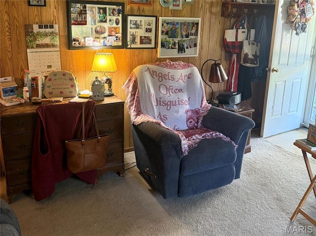 living area with carpet floors and wood walls