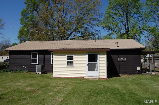 back of property featuring central AC and metal roof