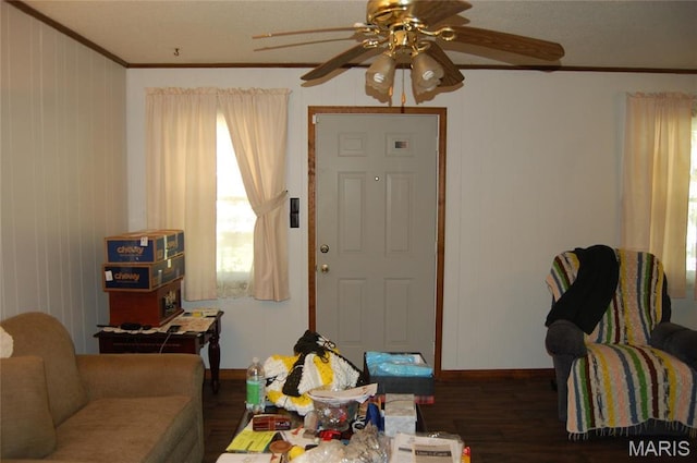 living room featuring a ceiling fan, ornamental molding, wood finished floors, baseboards, and healthy amount of natural light
