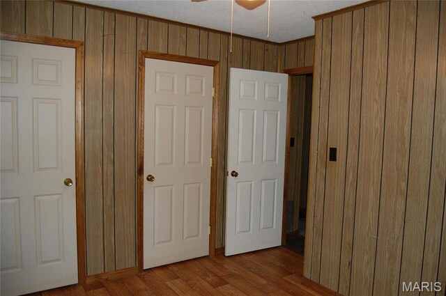 unfurnished bedroom featuring wooden walls and wood finished floors