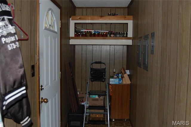 mudroom featuring wood walls and electric panel