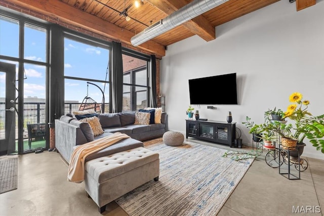 living area featuring wood ceiling, concrete floors, and beamed ceiling