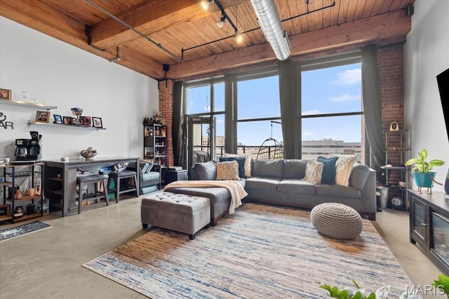 living room featuring wood ceiling, rail lighting, beam ceiling, and concrete floors