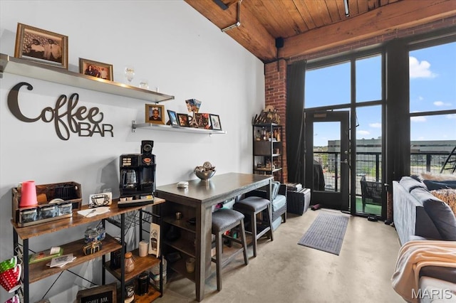 dining room with finished concrete flooring, healthy amount of natural light, and wooden ceiling