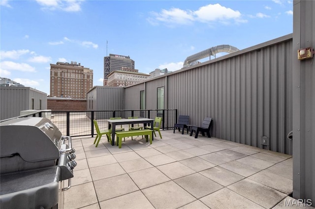 view of patio with area for grilling, a balcony, and outdoor dining space