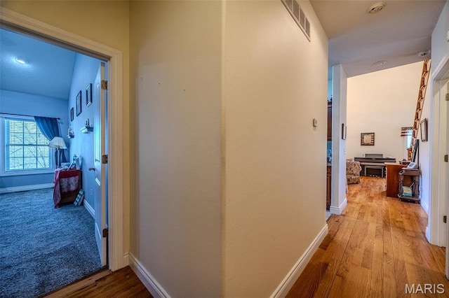 hallway featuring wood finished floors and baseboards