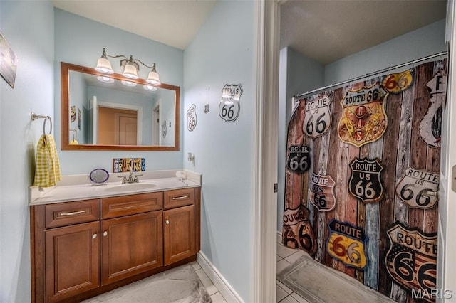 bathroom with tile patterned flooring, vanity, and baseboards
