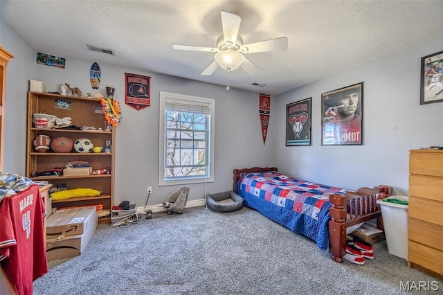 carpeted bedroom featuring a ceiling fan and a textured ceiling