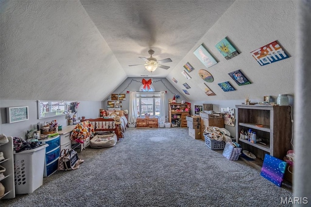playroom with a textured ceiling, carpet flooring, healthy amount of natural light, a ceiling fan, and lofted ceiling