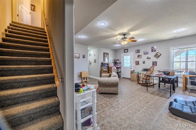 living area featuring a ceiling fan, stairway, a textured ceiling, light tile patterned floors, and recessed lighting