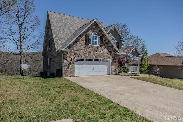 view of front facade featuring stone siding, driveway, a front yard, a porch, and central AC