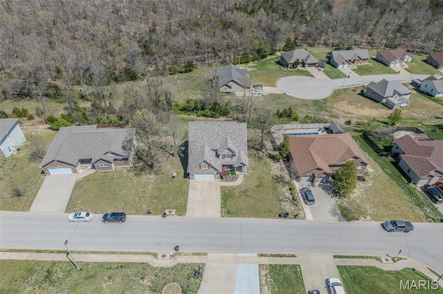 aerial overview of property's location featuring nearby suburban area and a forest