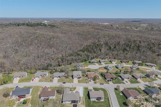 aerial view of property's location with a forest and nearby suburban area