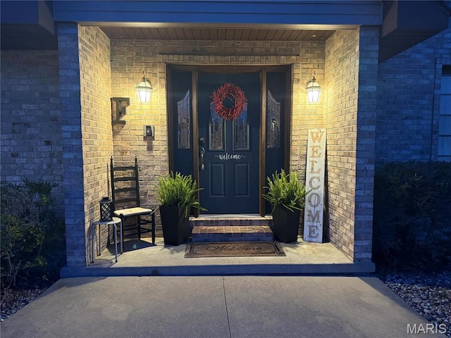 entrance to property featuring brick siding