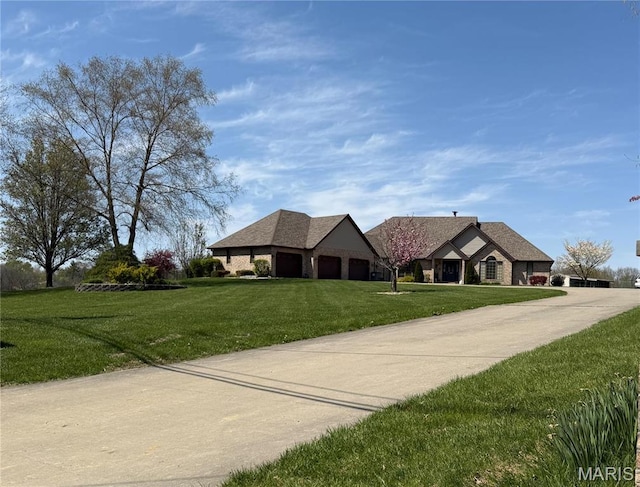 view of front facade with a front lawn, concrete driveway, and an attached garage