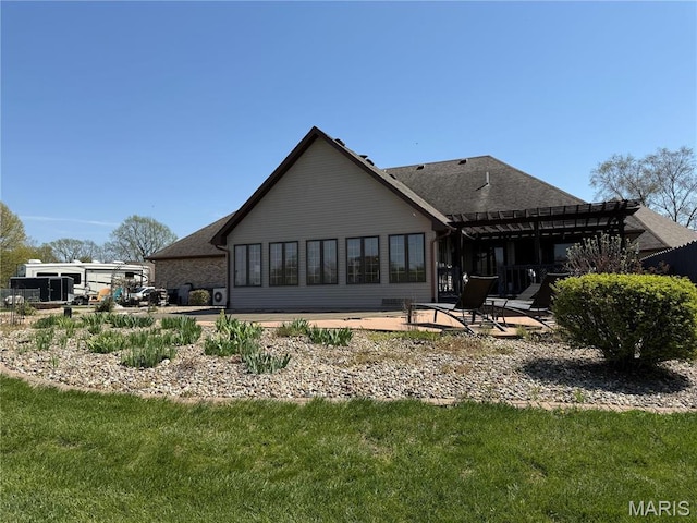 rear view of house featuring a pergola and a patio area