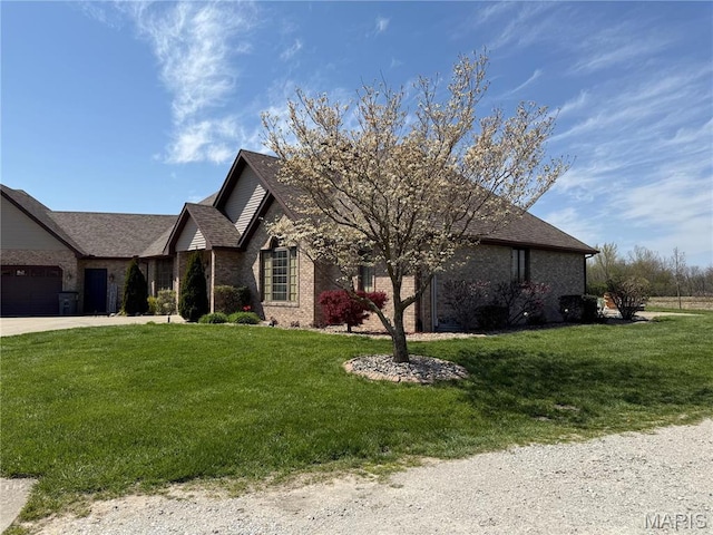view of front of property with a front yard, brick siding, a garage, and driveway