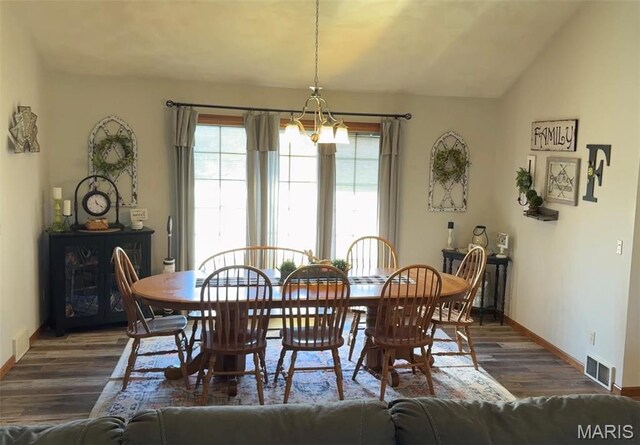 dining space featuring dark wood-style floors, plenty of natural light, baseboards, a chandelier, and vaulted ceiling
