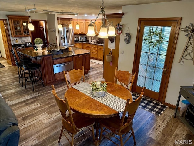 dining room with dark wood-style flooring, baseboards, and rail lighting