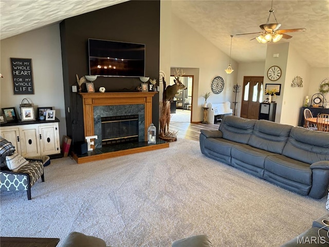 carpeted living room featuring lofted ceiling, a ceiling fan, a high end fireplace, and a textured ceiling