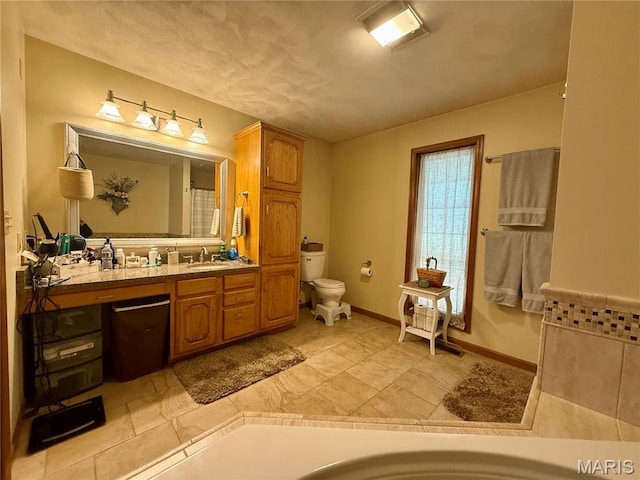 full bathroom featuring toilet, vanity, and baseboards