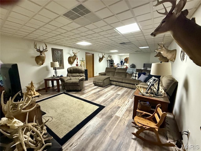 living room featuring wood finished floors and a drop ceiling