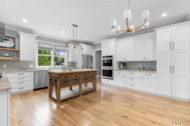 9870 E Concord Rd, Saint Louis, MO 63128 - kitchen with stainless steel appliances, backsplash, white cabinets, light wood-style floors, and recessed lighting
