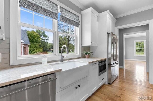 9870 E Concord Rd, Saint Louis, MO 63128 - kitchen with appliances with stainless steel finishes, a sink, ornamental molding, white cabinetry, and light stone counters