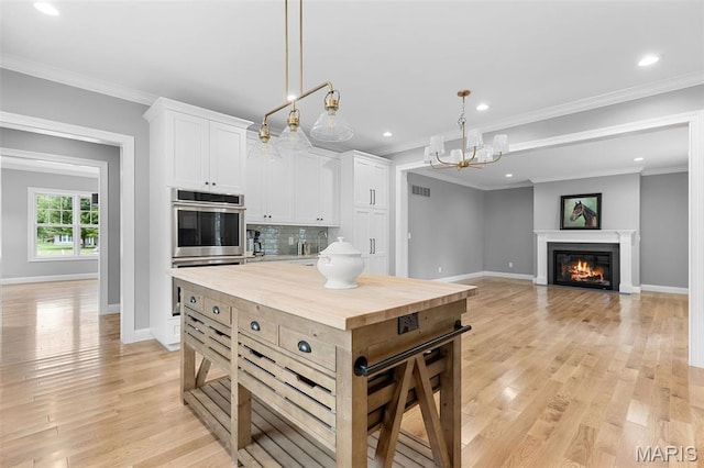 9870 E Concord Rd, Saint Louis, MO 63128 - kitchen with stainless steel double oven, wood counters, baseboards, decorative backsplash, and white cabinetry