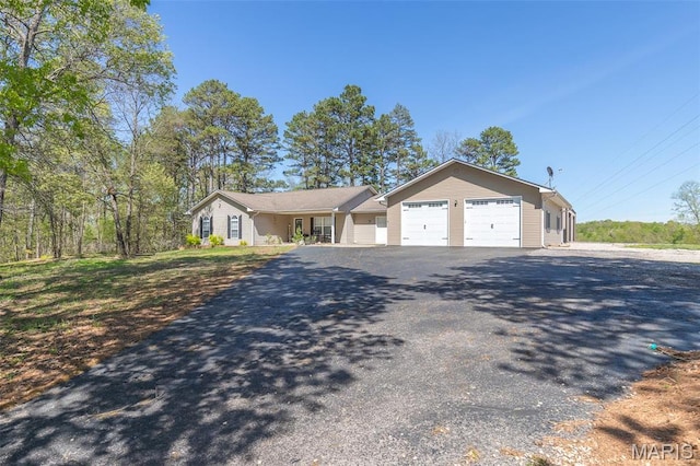 ranch-style home featuring asphalt driveway and a garage
