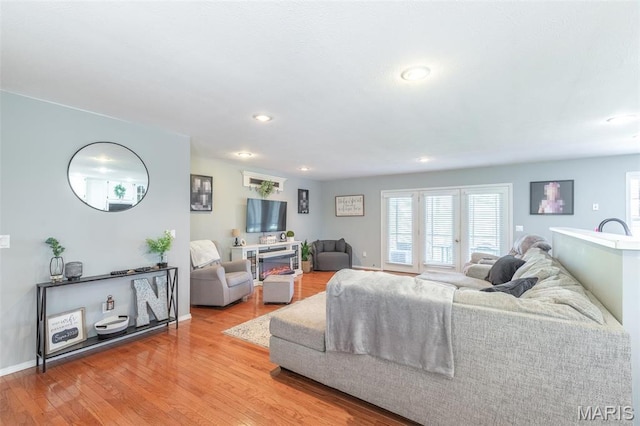 living area featuring wood finished floors, healthy amount of natural light, baseboards, and recessed lighting