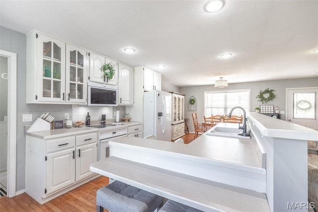 kitchen featuring white refrigerator with ice dispenser, a sink, electric stovetop, healthy amount of natural light, and recessed lighting